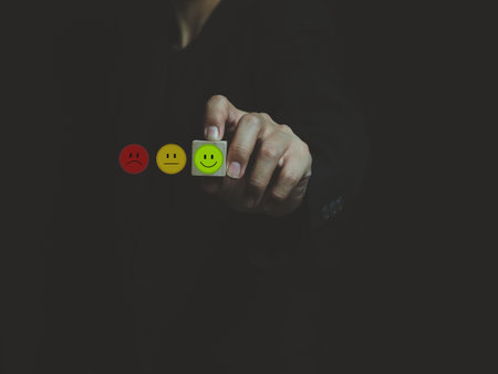 green smiley satisfaction expression icon in the wooden block on the hand of a businessman expression of satisfactionの写真素材