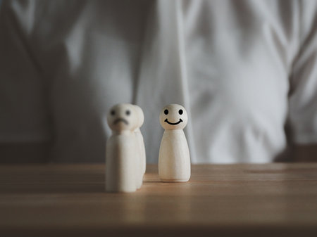 A wooden puppet isolated from the crowd or row. The unhappy face came out with a happy smiling face. different ideas dare to changeの写真素材