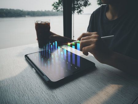 A man who is sitting and relaxing in a coffee shop is ready. business analysis Financial investment and technology development for success and growth. Analyze financial graphs on a virtual screen.の写真素材