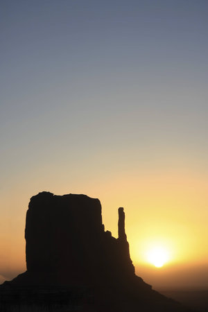Sunrise in Monument Valley with a stone formation in backlightの写真素材