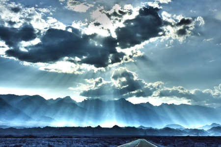 Mystery view of sun coming through clouds over a highwayの写真素材