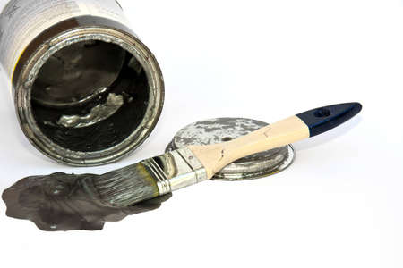 Brush with paint, a color pot and a lid over whiteの写真素材