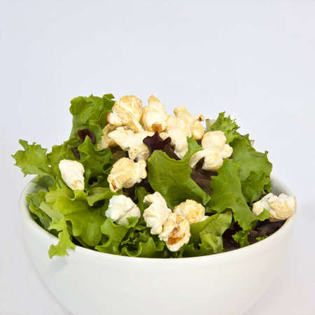Closeup of a bowl filled with salad and popcornの写真素材