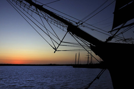 Sailing ship in backlight during sunsetの写真素材