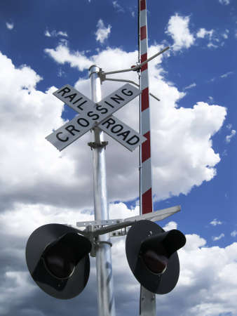 Railroad crossing sign with lights and barrierの写真素材