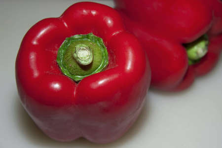 Two red peppers - one in blured backgroundの写真素材