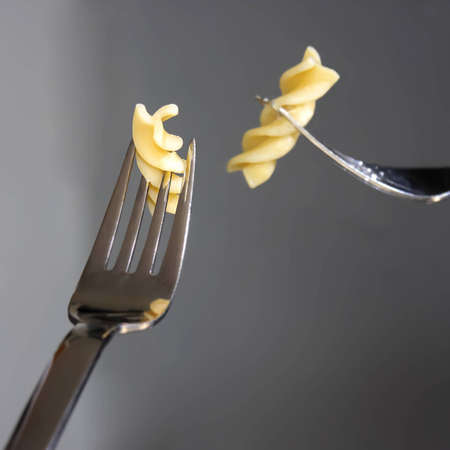 A noodle on a fork and their reflection in a mirrorの写真素材