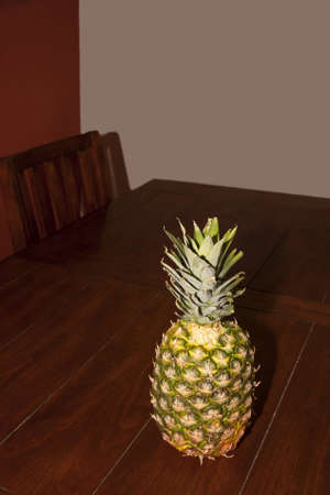 A pineapple on a rustic dinner tableの写真素材