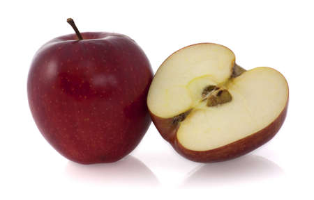 A whole red apple and a half of an apple at the rightの写真素材