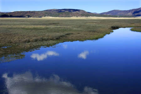 Reflections of the clouds in a river in the mountainsの写真素材