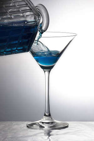 Pouring a liquid into a cocktail glass in a lighting atmosphereの写真素材