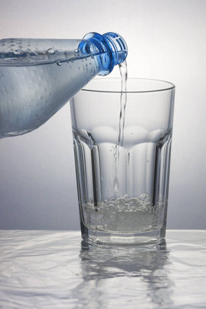 Pouring sparkling water into a caipirinha glassの写真素材