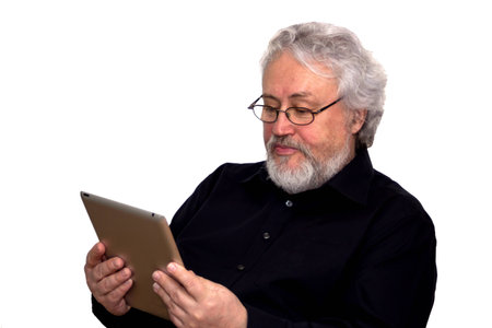 A senior with grey hair is holding a tablet and looking at itの写真素材