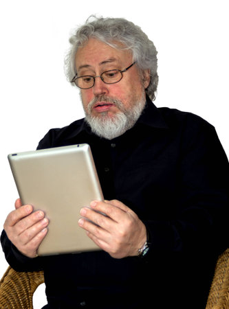 A senior with grey hair is holding a tablet and looking at it helplessの写真素材