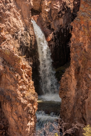 A waterfall in between huge rocksの写真素材