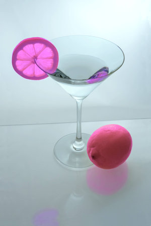 Martini glass with pink lemon slice and pink lemon from aboveの写真素材