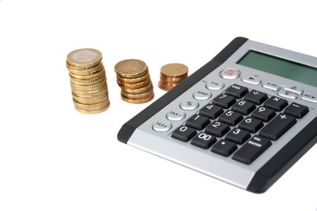 Calculator and coin stacks in backgroundの写真素材