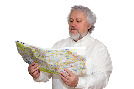 Senior is looking at a map he is holding in his handsの写真素材