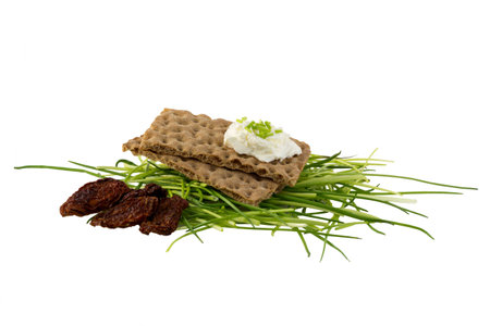 Crispbread with cream cheese, chives and dried tomatoesの写真素材
