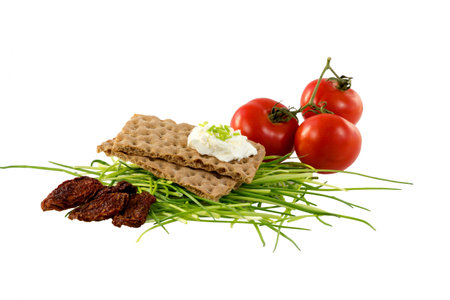 Crispbread with cream cheese, chives and tomatoesの写真素材