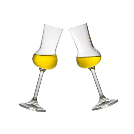 Two toasting filled Grappa glasses isolated on whiteの写真素材