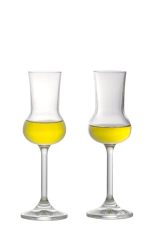 Two filled Grappa Glasses standing upright isolated on whiteの写真素材