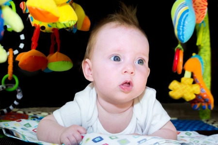 Portrait shot of an almost four month old baby girl playingの写真素材