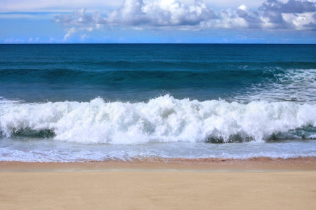 Untouched empty sandy beach with incoming strong surfの写真素材
