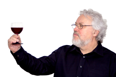 A gray haired bearded senior is tasting red wine isolated on white