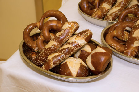 Laugen pretzels and sticks in bowls on a table with white tableclothの写真素材