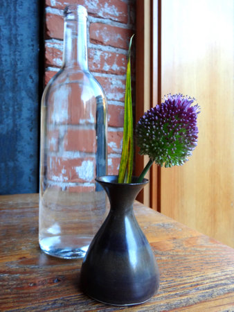 Still life of a bottle and a flower in a vaseの写真素材