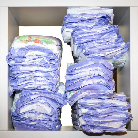Square shot of diapers placed on a shelf of a white open cupboardの写真素材