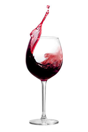 Red wine is splashing out of a wine glassの写真素材
