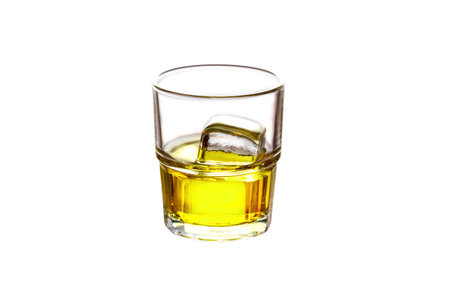 Glass filled with whiskey and ice isolated on whiteの写真素材