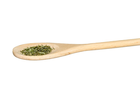 Minced rosemary on a wooden spoon isolated on whiteの写真素材