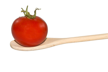 Tomato on a wooden spoon isolated on whiteの写真素材