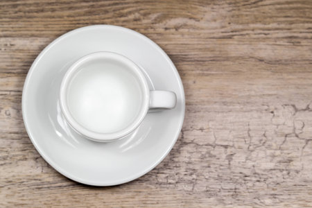 Empty clean espresso cup on wooden table with blurred background from aboveの写真素材