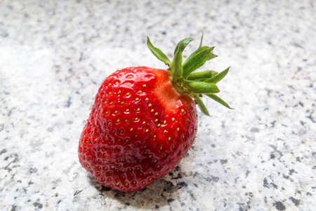 A single fresh strawberry in natural lightの写真素材
