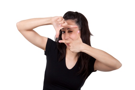 Portrait of young woman creates a frame with her hands, isolated on white background の写真素材