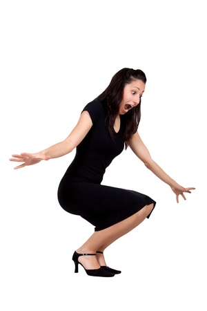 Brunette woman in black dress is squatting and be scared, isolated on white backgroundの写真素材