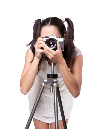 Retro woman in white dress, take pictures, with an old camera on a tripod isolated on white backgroundの写真素材