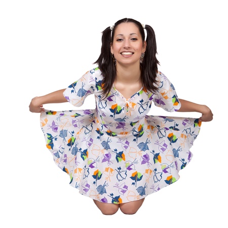 A girl with pigtails in colorful retro dress, a bending forward, stretched skirt, isolated on white backgroundの写真素材