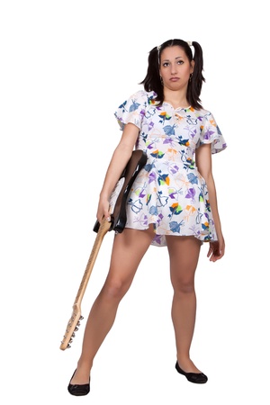 Woman in colorful retro dress, standing bored and holding an electric guitar, isolated on white backgroundの写真素材