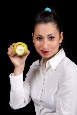 The woman holds in hand green nibbled apple stained with lipstickの写真素材