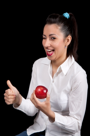 Woman holding red apple in hand and shows a raised fingerの写真素材