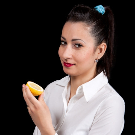 The woman holds in hands a yellow lemonの写真素材