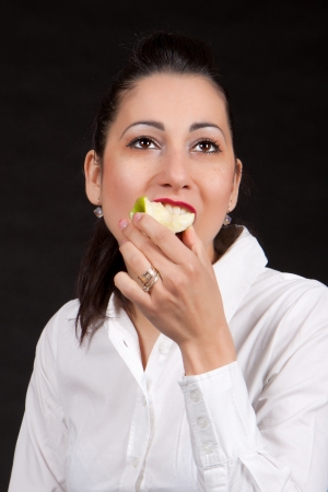 Female bite on green appleの写真素材