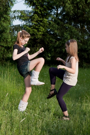 Two teens dancing girls in grass on a meadowの写真素材
