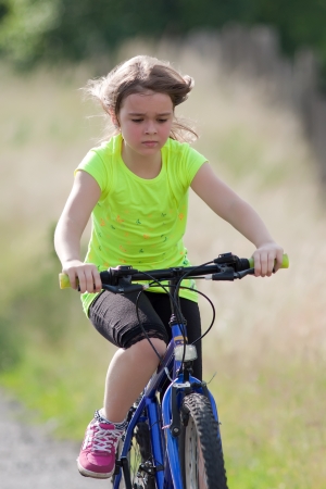 Portrait of teen girl in neon yellow shirt on a bikeの写真素材