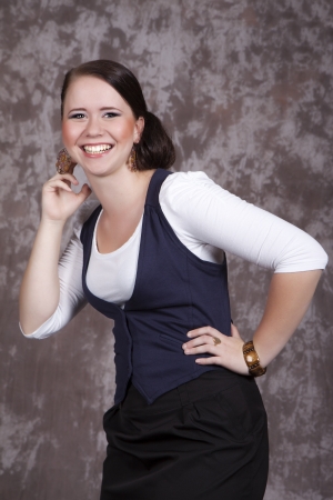 Portrait of a girl with long hair in a white shirt and a blue jacket laughsの写真素材